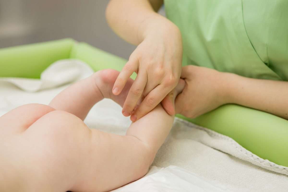一位准备进入 IVF 周期的女性正在接受针灸调理，针灸师在下腹部与腰骶部精准取穴，以提升助孕效果。